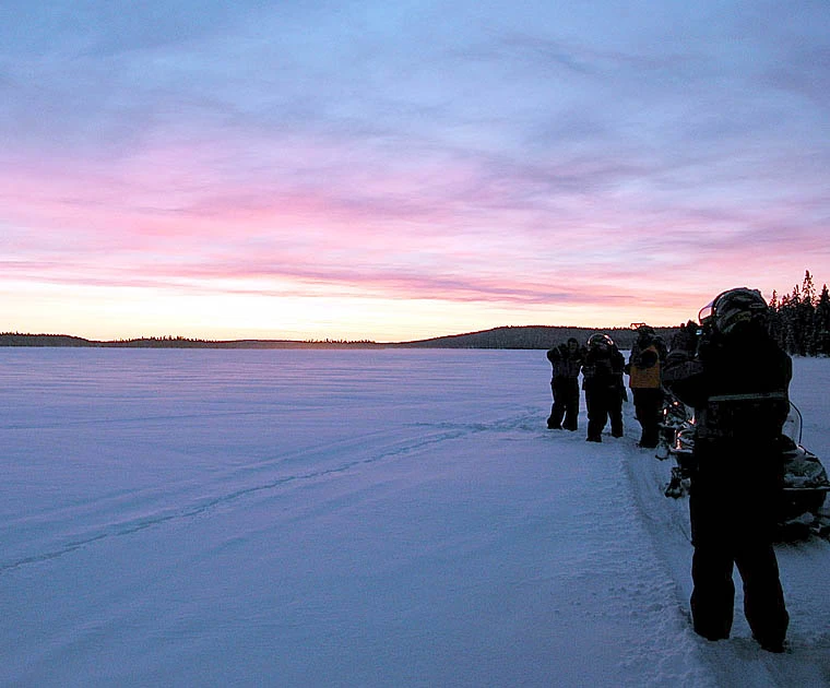 Motoneiges au coucher du soleil en Laponie