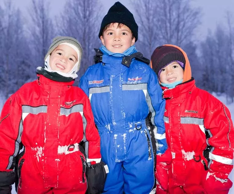 Des enfants bien couverts pour jouer dans la neige en Laponie
