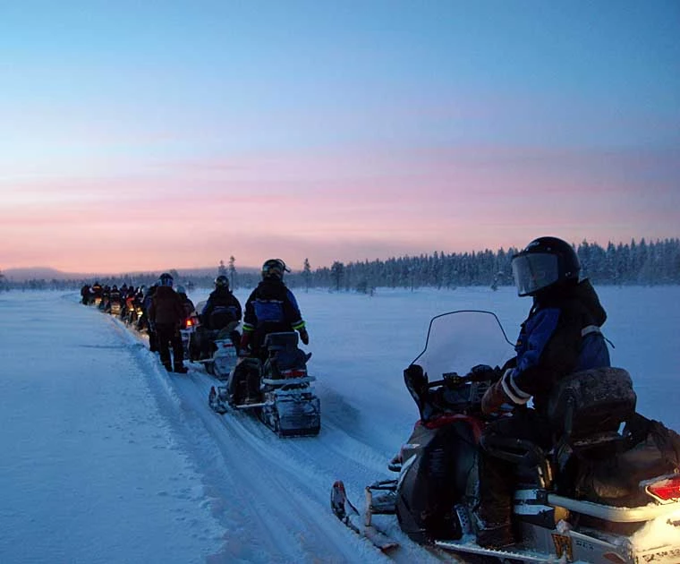 Motoneiges dans la nuit polaire en Laponie