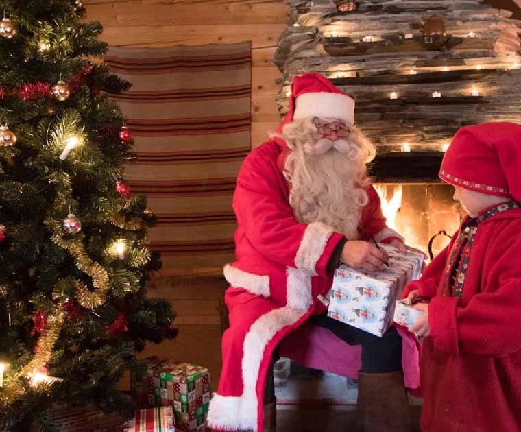 Père Noël prépare les cadeaux avec son lutin dans sa maison en Laponie