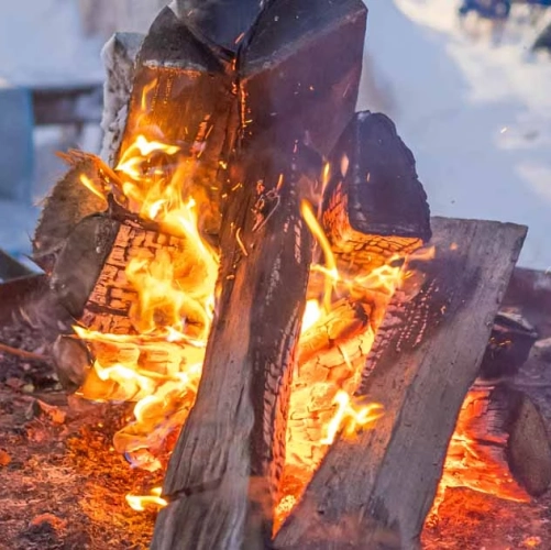 Allumage d'un feu de bois en pleine nature enneigée