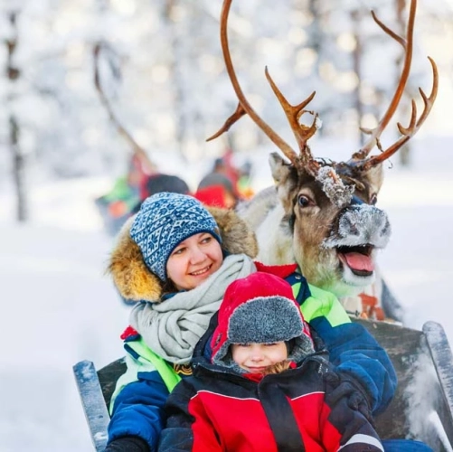 Mère et fille dans un traineau de renne avant les ateliers du Père Noël
