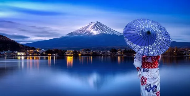 Une japonaise tenant son wagasa face au mont Fuji au Japon