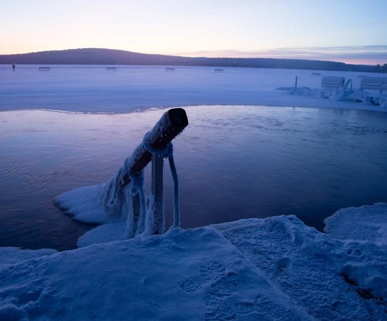 Baignade dans un avanto d'un lac semi-gelé à Noël