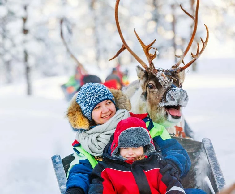 Mère et fille dans un traineau de renne avant les ateliers du Père Noël