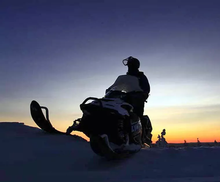 Motoneige au coucher du soleil en Laponie