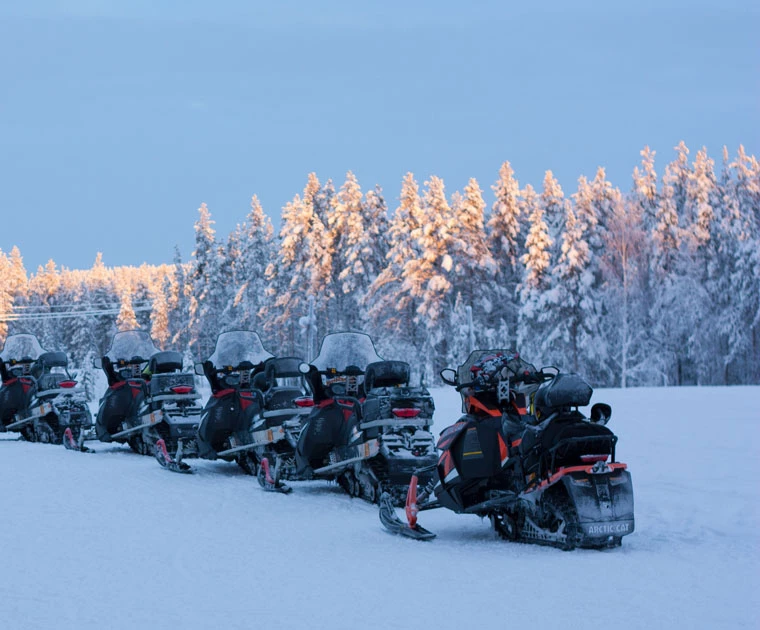 Motoneiges dans le paysage enneigé de Laponie