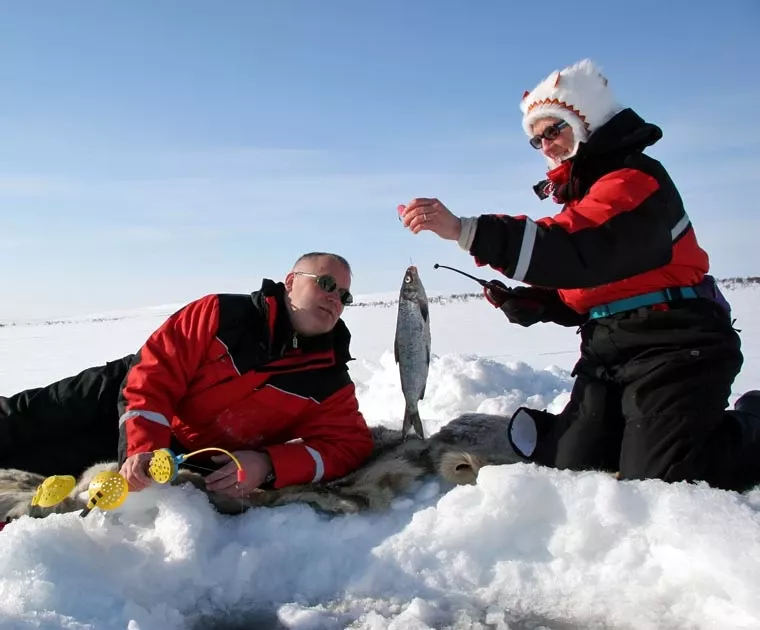 Un couple de pêcheurs sous la glace a attrapé un poisson en Laponie