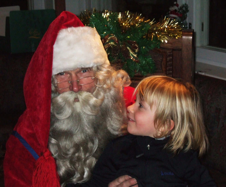 Un enfant sur les genoux du Père Noël lors de la soirée de remise des cadeaux
