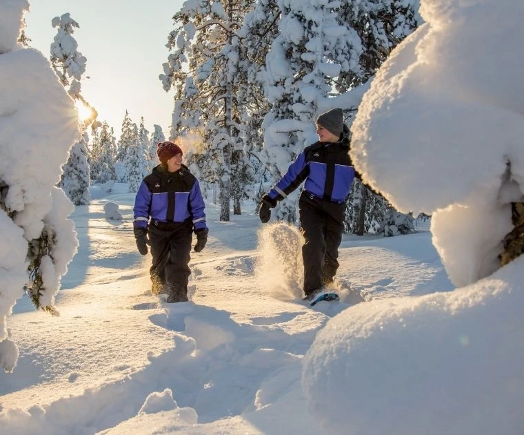 Deux femmes en raquettes prennent plaisir à fouler la neige profonde sous le soleil