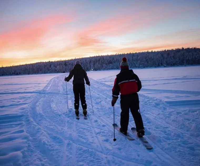 Ski de fond sur le lac avec le soleil affleurant en Laponie